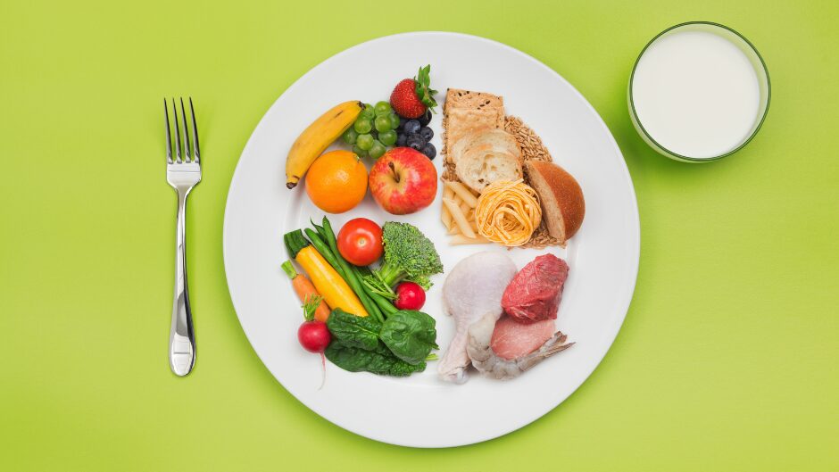 炭水化物、タンパク質、野菜、果物、バランスのとれた食事をイメージした一皿。