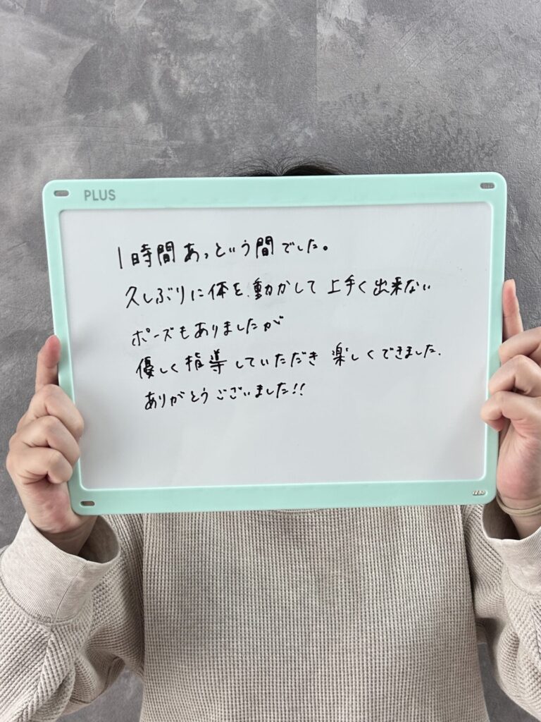 レッスン後の感想を書いて顔を隠してホワイトボードを持っている写真